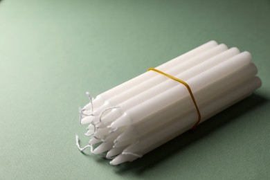 Many church wax candles on olive background. Space for text