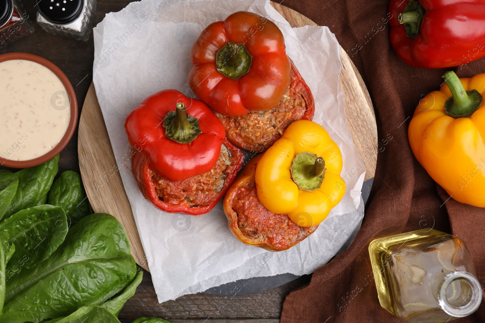 Photo of Delicious stuffed bell peppers served on wooden table, flat lay