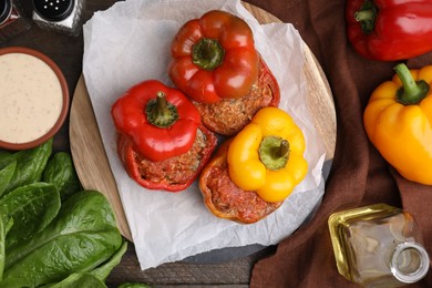 Photo of Delicious stuffed bell peppers served on wooden table, flat lay