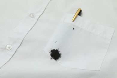 Photo of White shirt with stain of black ink and pen in pocket, closeup