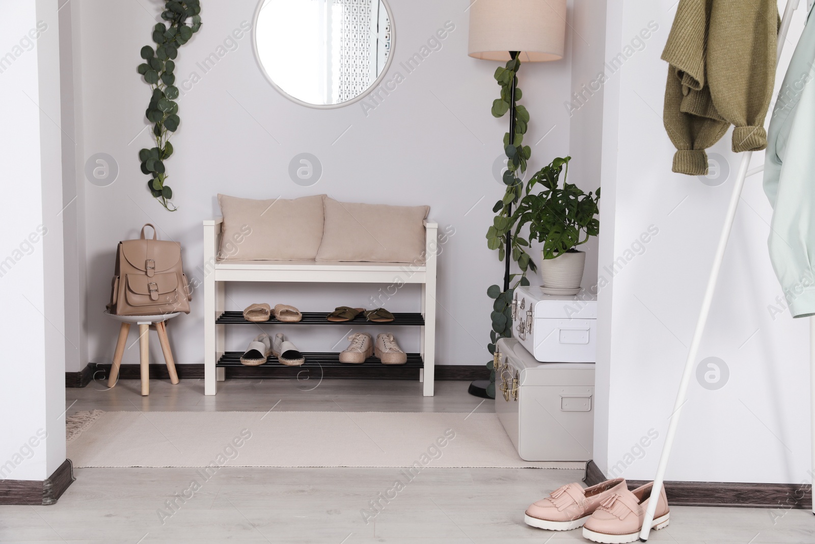 Photo of Hallway interior with stylish shoe storage bench and houseplants