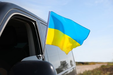 National flag of Ukraine on car window outdoors, closeup