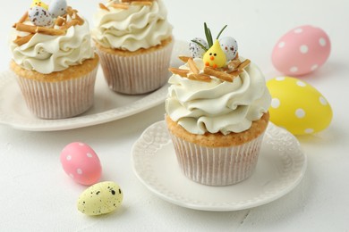 Tasty Easter cupcakes with vanilla cream on white table, closeup