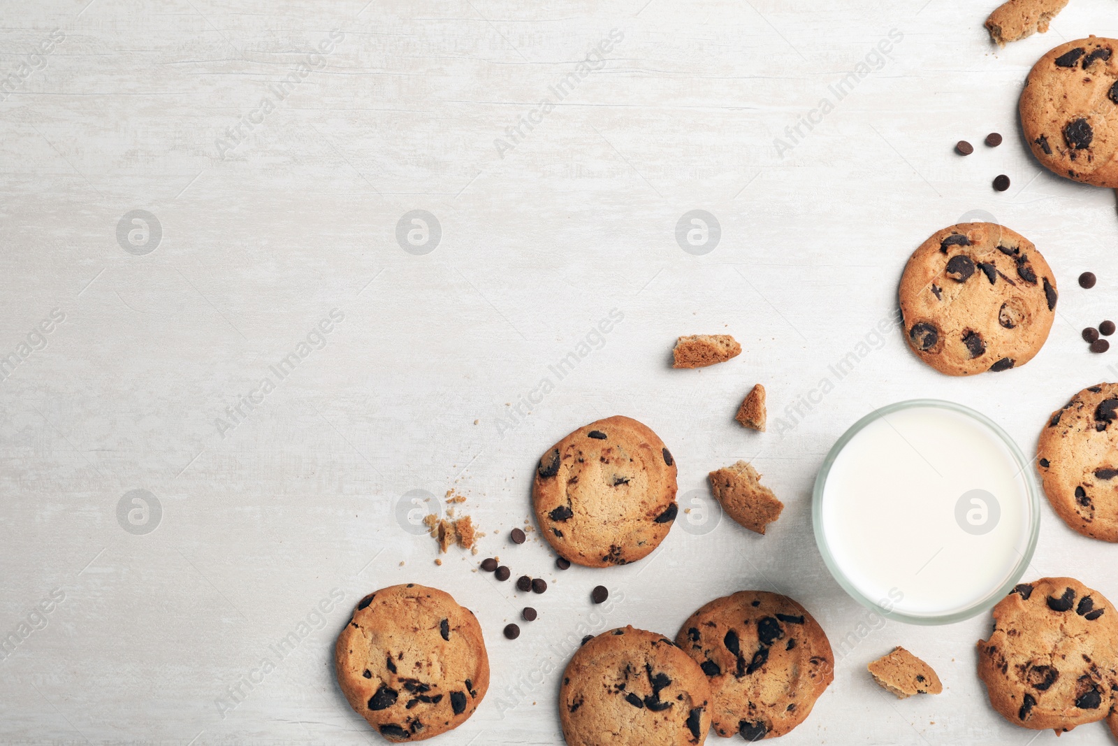 Photo of Flat lay composition with chocolate cookies and glass of milk on light background. Space for text