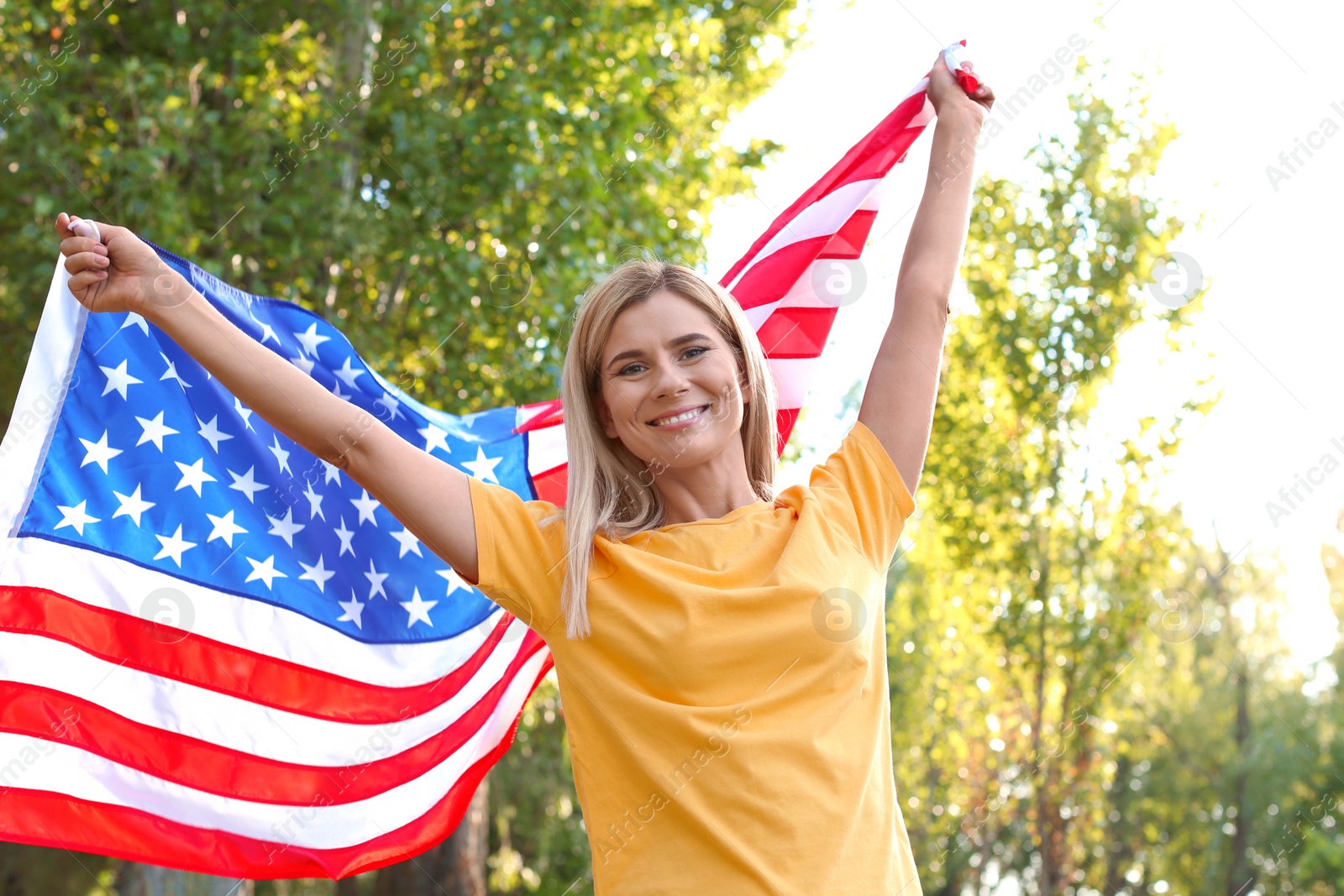 Photo of Woman with American flag in park on sunny day