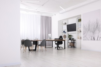 Photo of Stylish office with comfortable furniture and tv zone. Interior design
