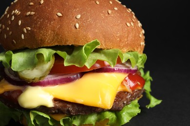 Delicious burger with beef patty and lettuce on black background, closeup