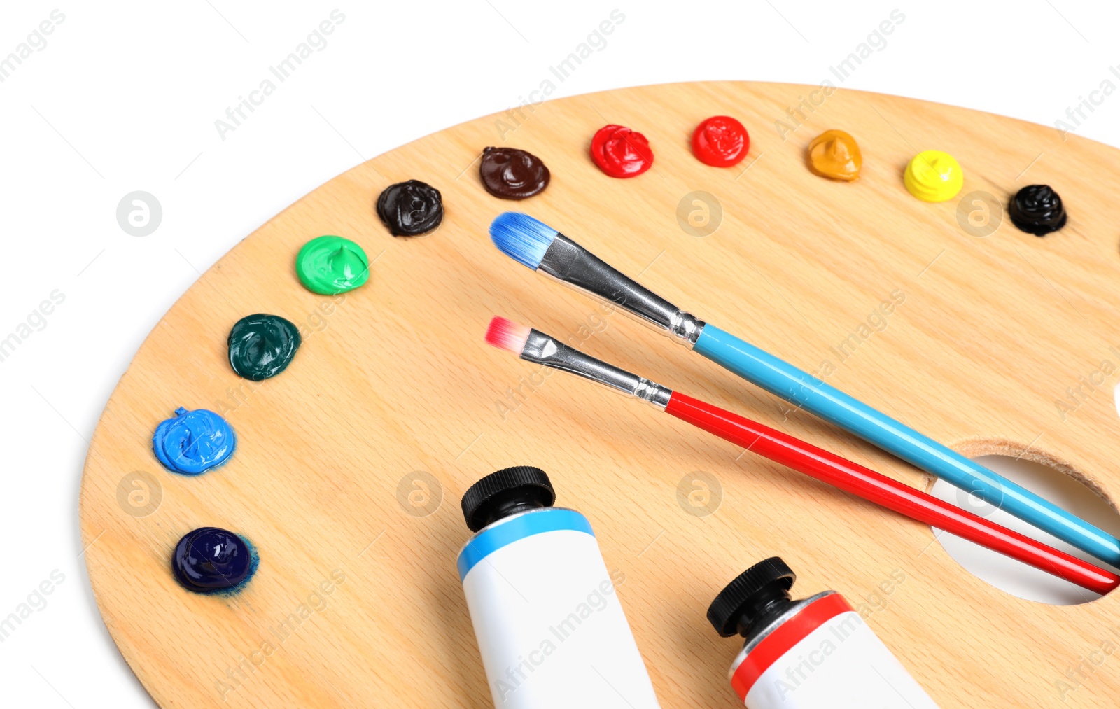 Photo of Palette with acrylic paints and brushes on white background, closeup. Artist equipment