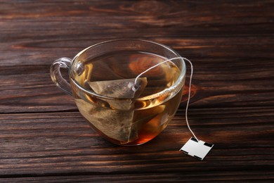 Tea bag in glass cup on wooden table
