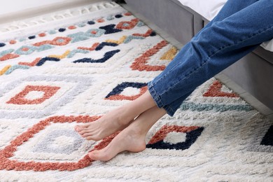 Woman on carpet with pattern at home, closeup