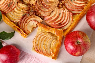 Photo of Tasty apple pie with nuts and fresh fruits on table, flat lay
