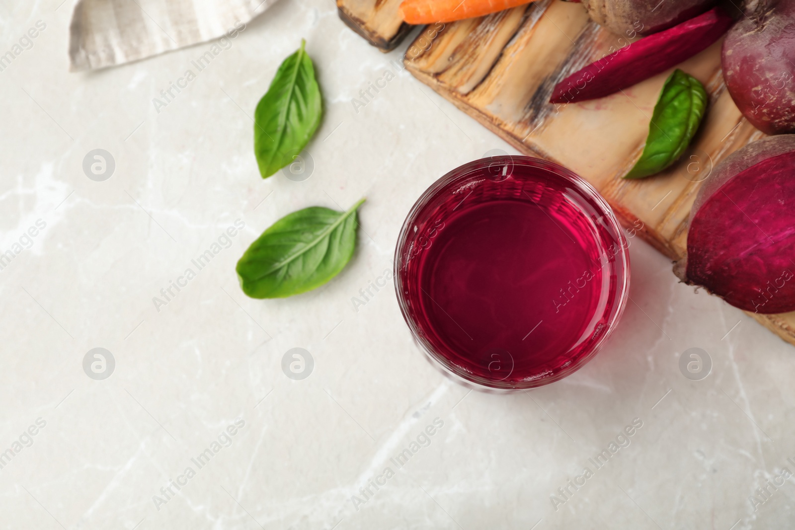 Photo of Glass with fresh beet juice and ingredients on table, top view