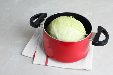 Photo of Sauce pan with hot water and cabbage for preparing stuffed rolls on light table