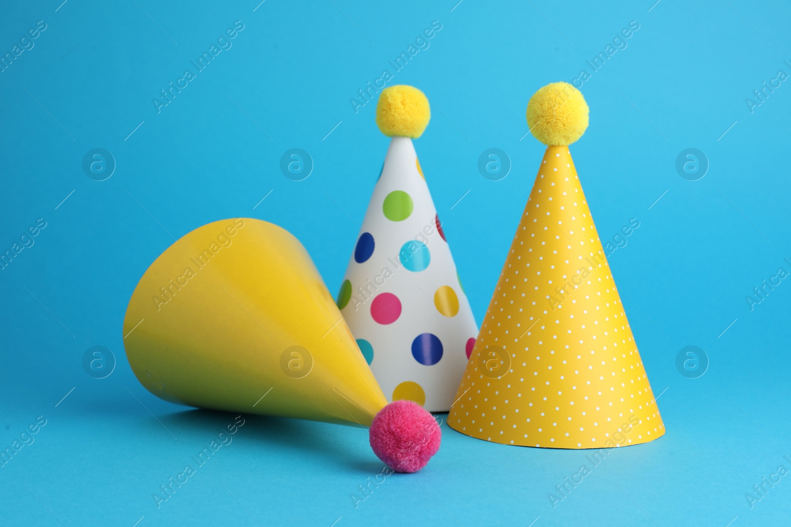 Photo of Colorful party hats on light blue background