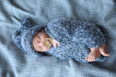 Cute newborn baby sleeping on blanket, top view