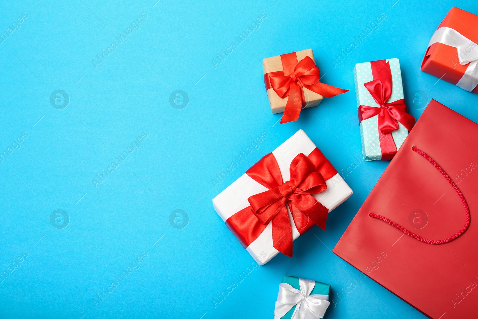 Photo of Flat lay composition with shopping bag and gifts on color background