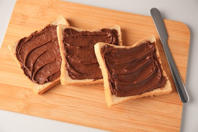 Tasty toasts with chocolate paste on beige background, above view