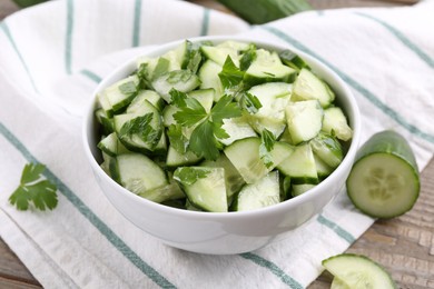 Delicious cucumber salad in bowl on table