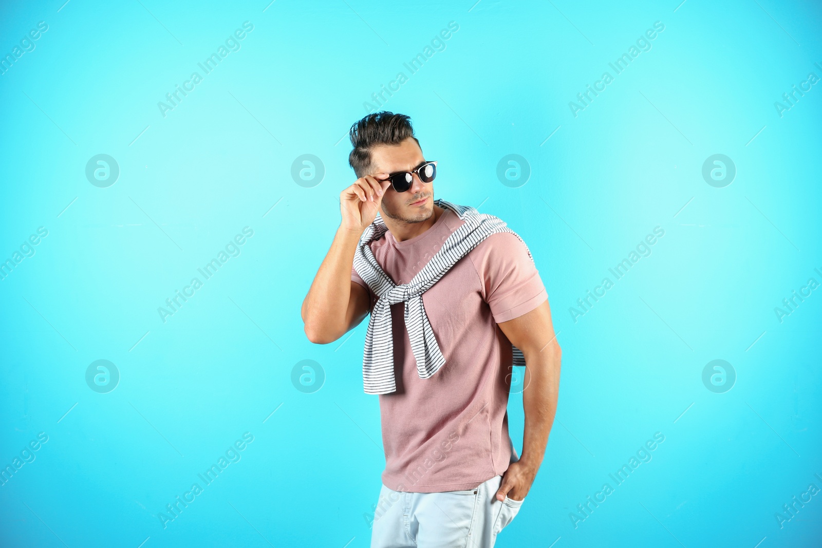 Photo of Young man in stylish jeans on color background