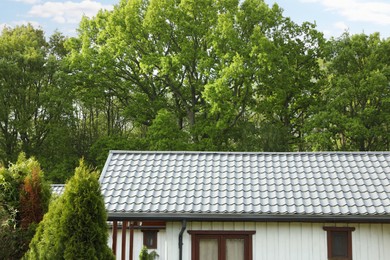 Photo of Modern building with grey roof outdoors on spring day