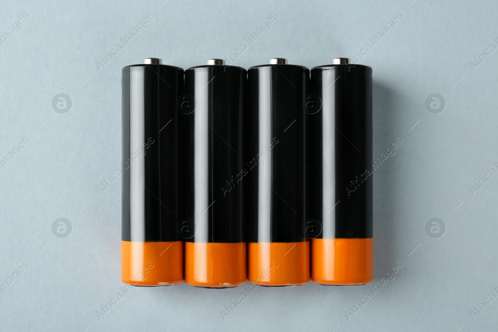 Image of New AA batteries on light background, flat lay