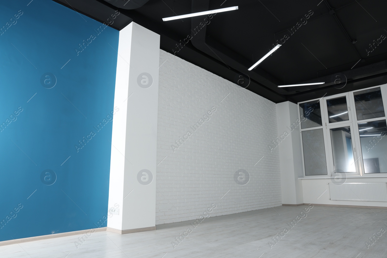 Photo of Empty office room with black ceiling and clean windows. Interior design