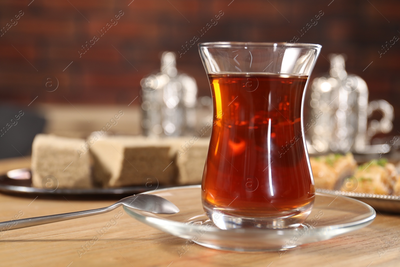 Photo of Traditional Turkish tea in glass on wooden table, closeup. Space for text