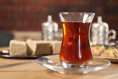 Traditional Turkish tea in glass on wooden table, closeup. Space for text