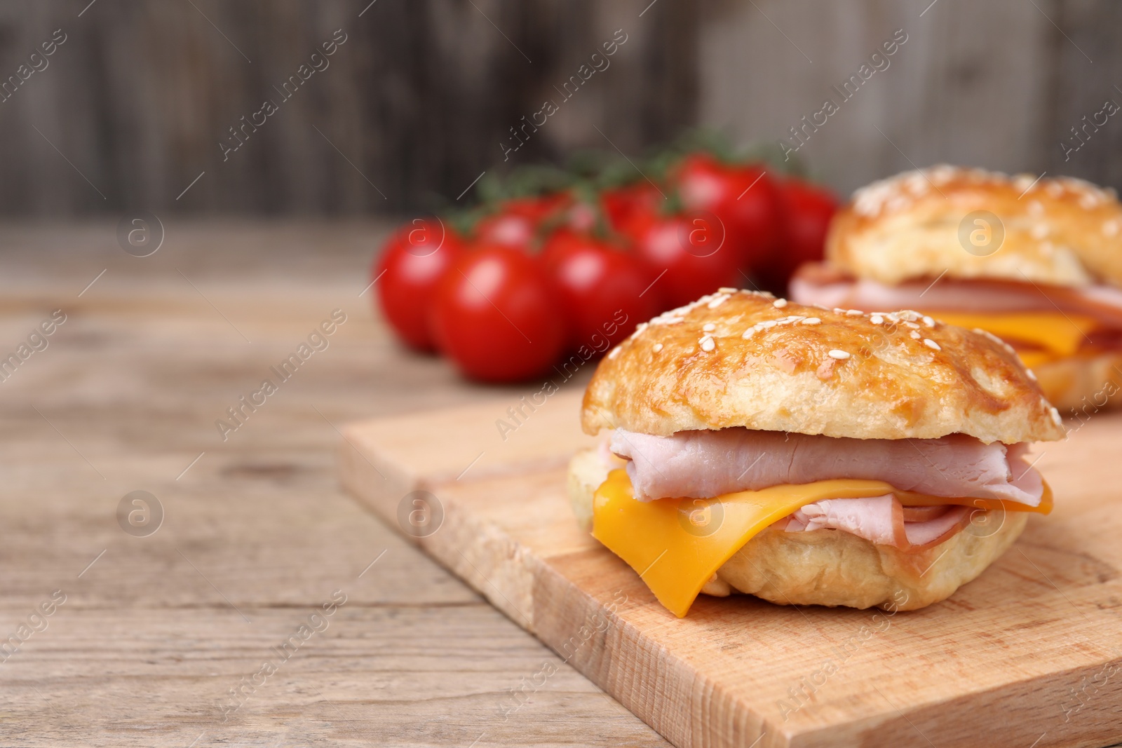 Delicious bagels with ham and cheese on wooden table. Space for text Photo of Delicious bagels with ham and cheese on wooden table. Space for text