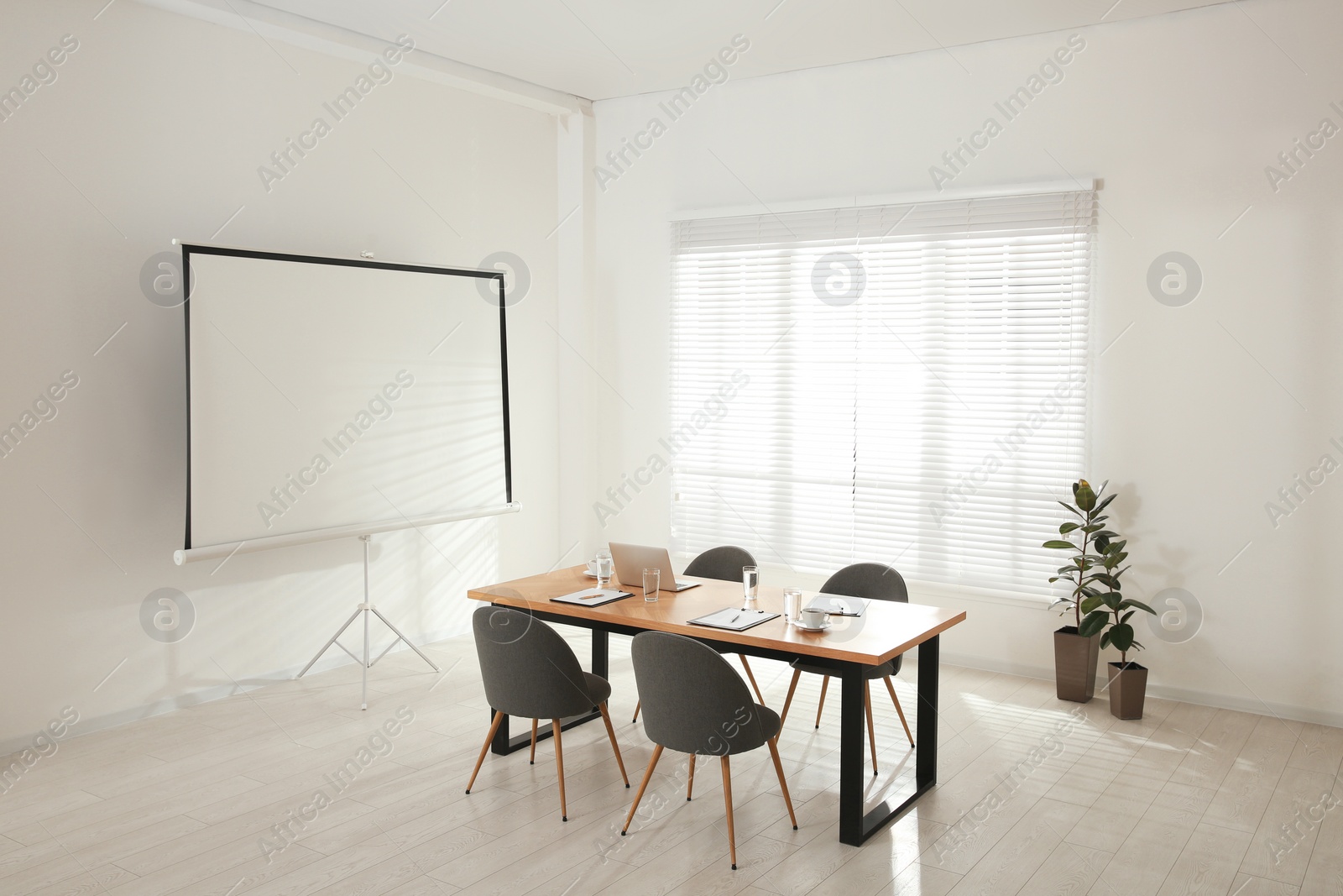 Photo of Conference room interior with wooden table and video projection screen