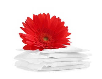 Photo of Stack of menstrual pads and gerbera flower on white background. Gynecological care