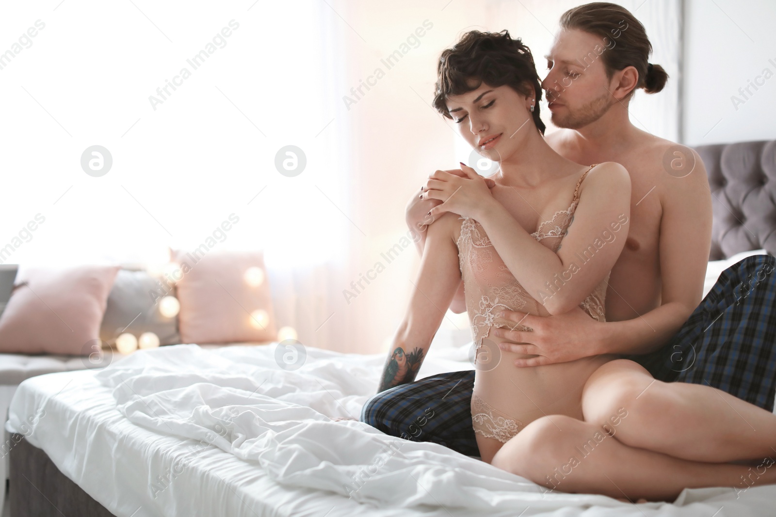 Photo of Lovely young couple being intimate on bed at home