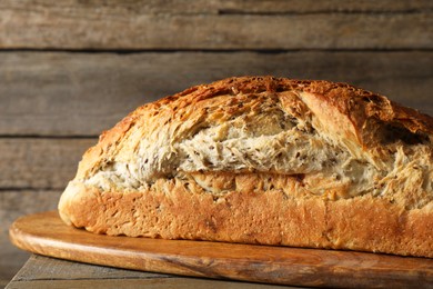 Photo of Freshly baked sourdough bread on wooden table, closeup