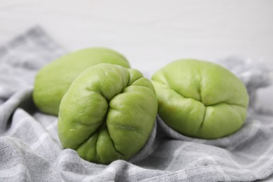 Photo of Fresh green chayote on gray napkin, closeup