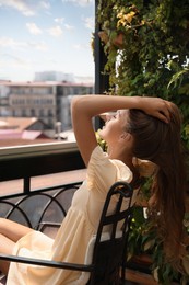 Photo of Beautiful young woman enjoying her time on balcony
