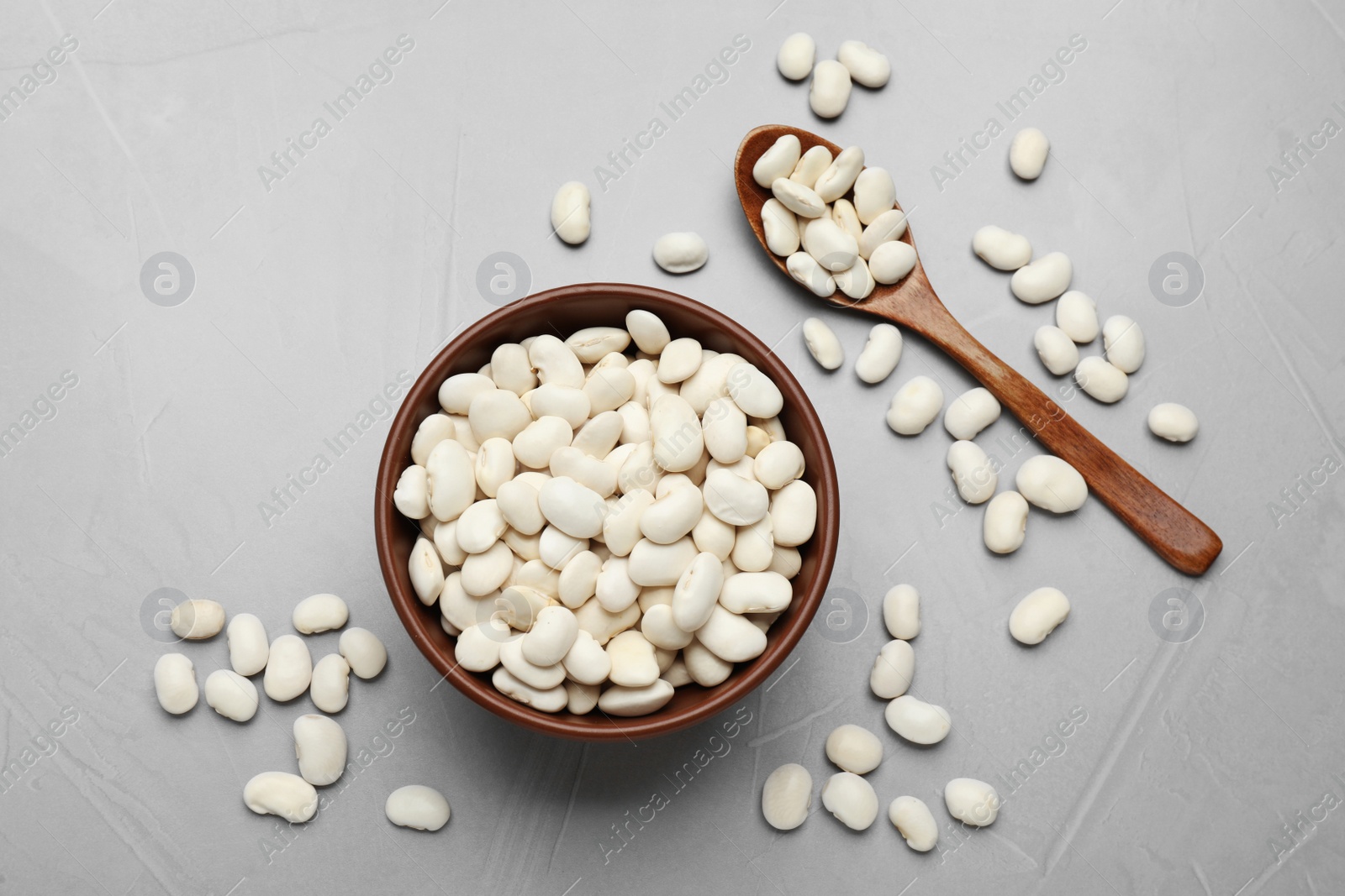 Photo of Raw white beans on light grey table, flat lay