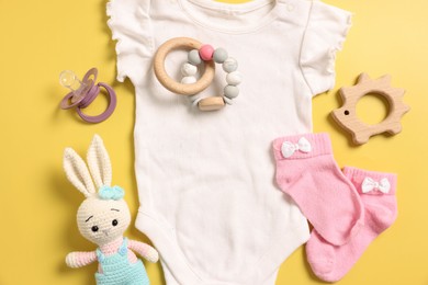 Photo of Different baby accessories on yellow background, flat lay