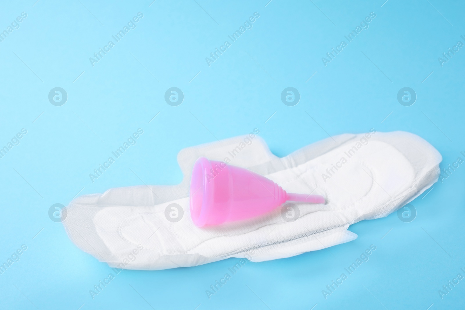 Photo of Pad and menstrual cup on color background. Gynecological care