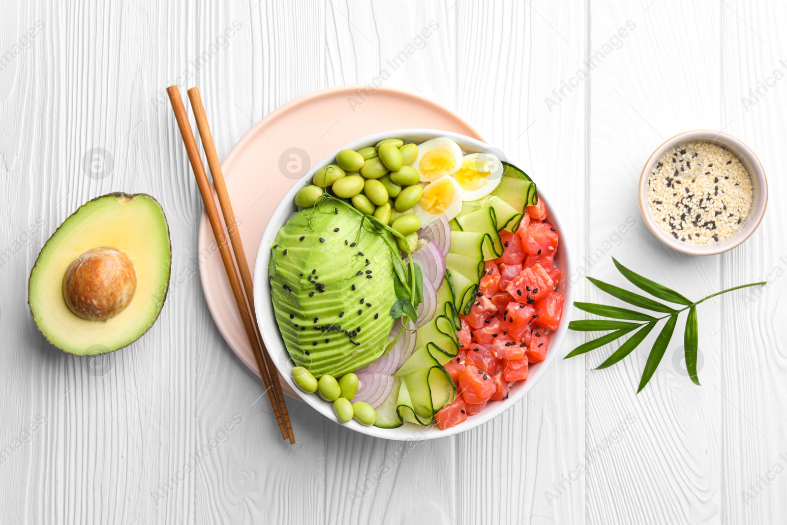 Photo of Delicious poke bowl with avocado, fish and edamame beans on white wooden table, flat lay