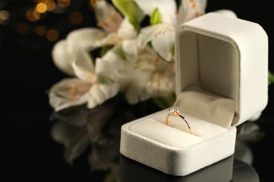 Photo of Beautiful engagement ring in box against blurred background, space for text