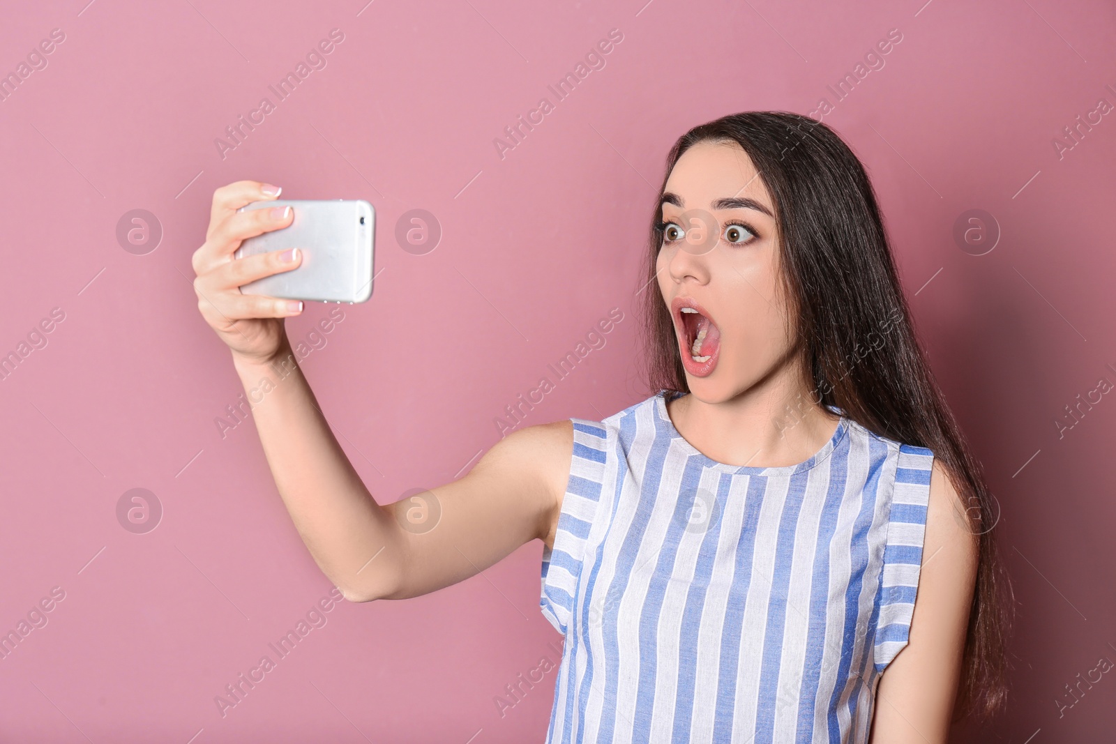 Photo of Young beautiful woman taking selfie against color background