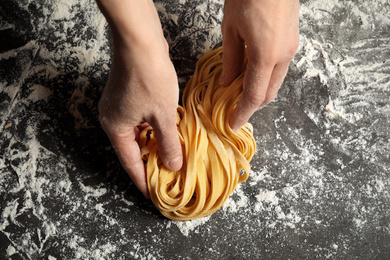 Photo of Woman holding pasta at table, top view