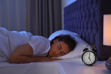 Handsome young man sleeping on pillow at night. Bedtime