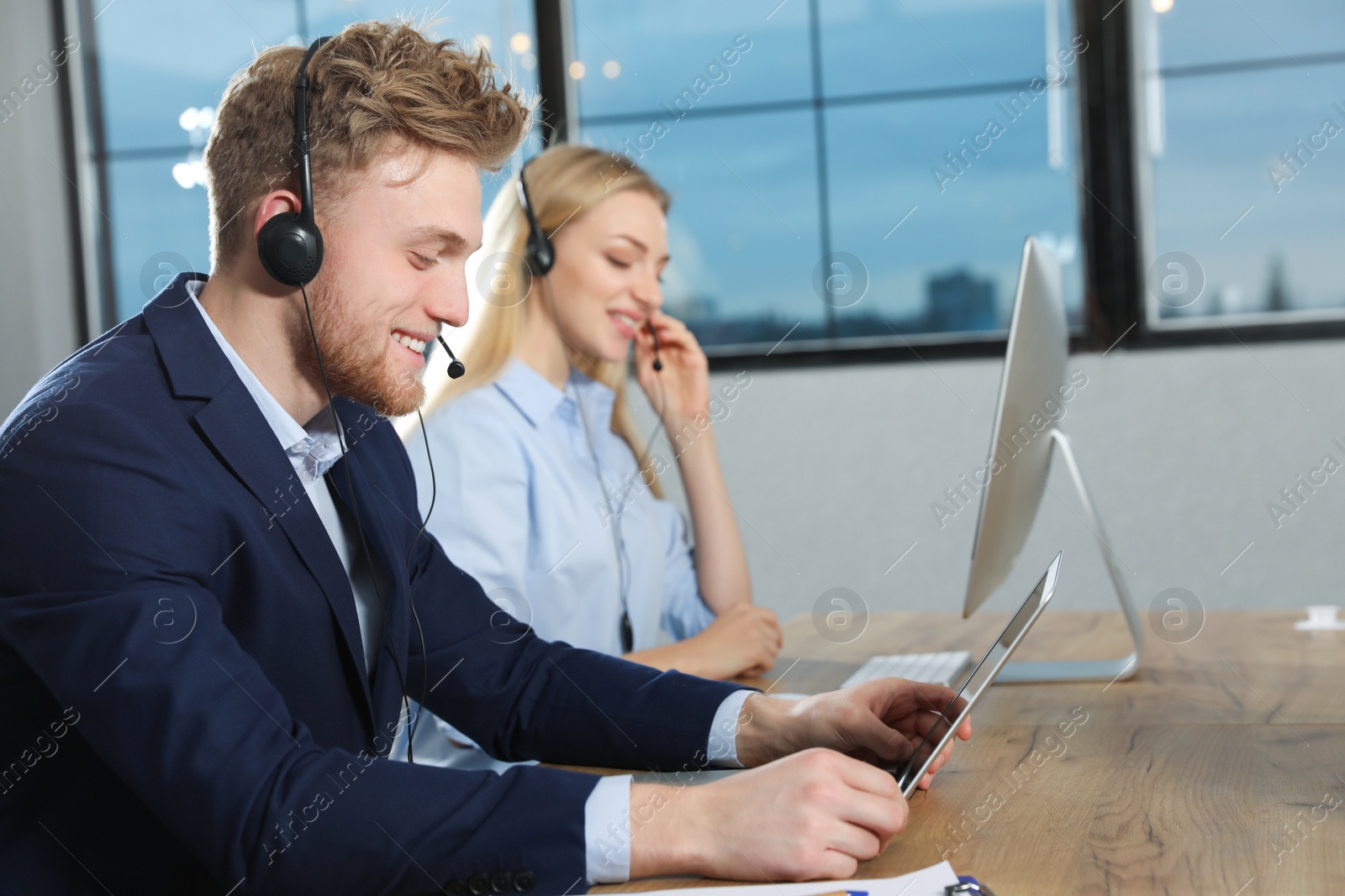 Photo of Technical support operator with colleague in modern office