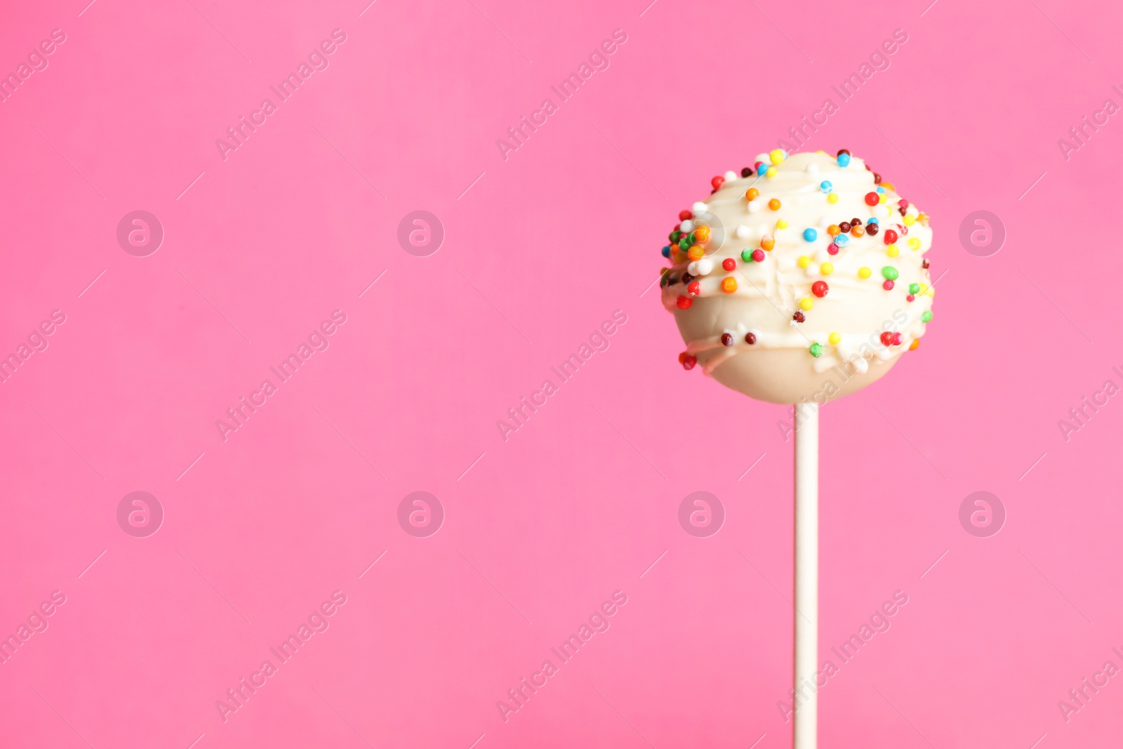 Photo of Bright delicious cake pop on color background. Space for text