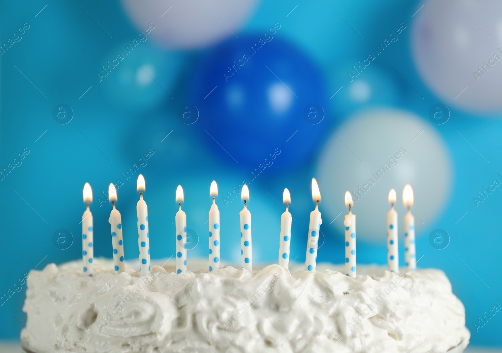 Photo of Birthday cake with burning candles on blurred background, closeup