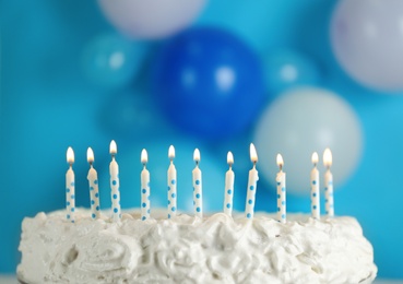 Birthday cake with burning candles on blurred background, closeup