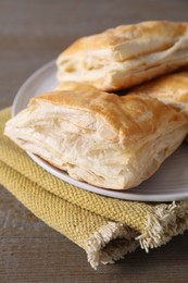 Delicious fresh puff pastries on wooden table, closeup