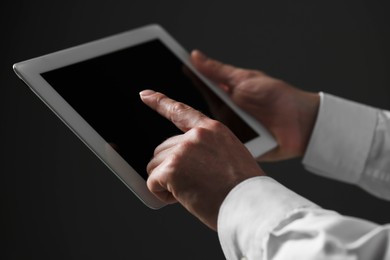 Closeup view of man using new tablet on black background