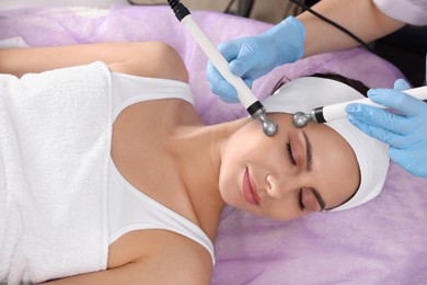 Young woman undergoing cosmetic procedure in beauty salon. Microcurrent therapy